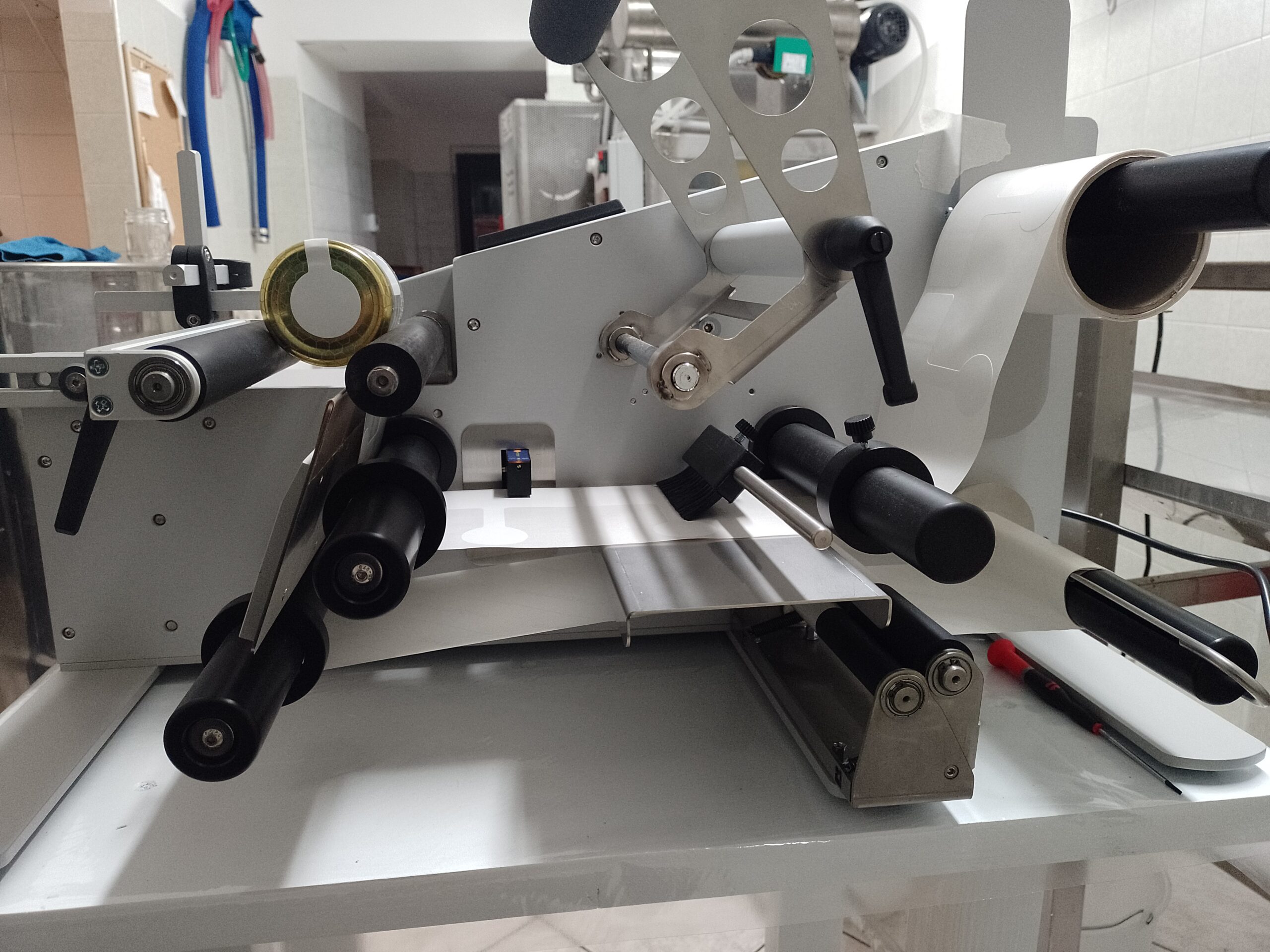 Macchina etichettatrice con un vasetto di miele nel laboratorio Terra e Api